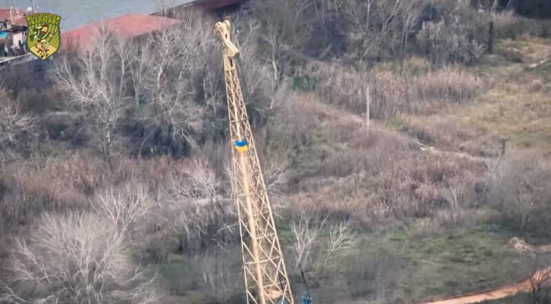 A screengrab from a video posted on Facebook showing a Ukraine flag flying from a crane the Dnipro river. @Спецпідрозділ "Карлсон" / Facebook
