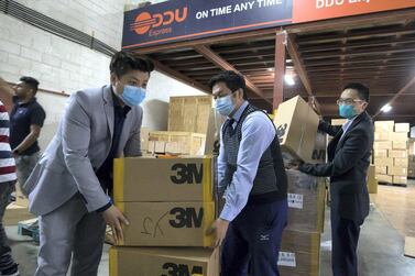 Volunteers help with boxes of face masks to be shipped to China. Leslie Pableo / The National