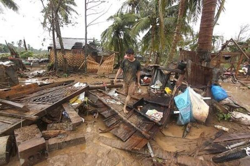 Residents walk amongst their destroyed houses after Typhoon Bopha hit Compostela town, Compostela Valley province, in southern island of Mindanao on December 4, 2012.  Typhoon Bopha killed 43 people in one hard-hit Philippine town December 4, local television station ABS-CBN reported from the scene.   AFP PHOTO/Karlos Manlupig

 *** Local Caption ***  031797-01-08.jpg