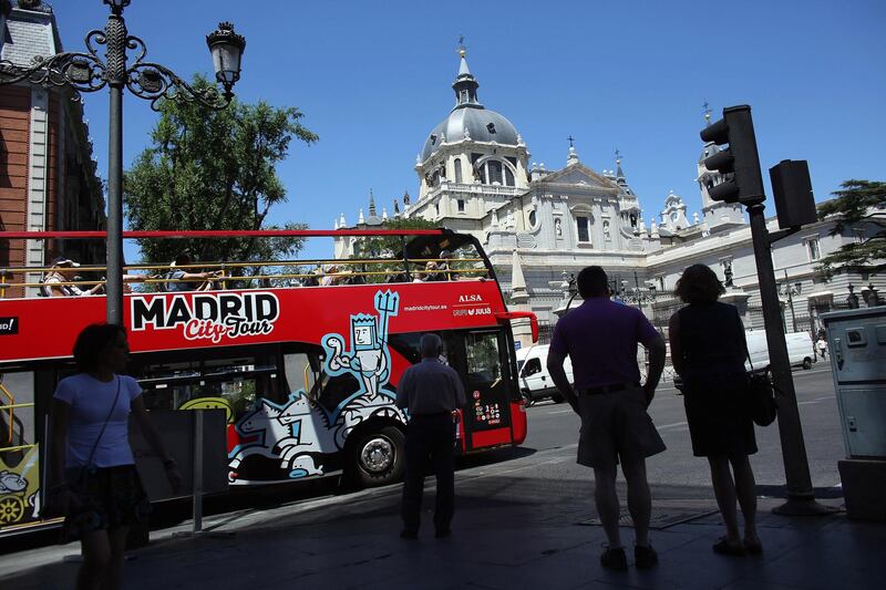 MADRID, SPAIN - JULY 07:  Tourists ride a sightseeing bus past the Catedral de la Almudena on July 7, 2012 in Madrid, Spain. Despite having the fourth largest economy in the Eurozone, the economic situation in Spain remains troubled with their unemployment rate the highest of any Eurozone country. Spain is currently administering billions of euros of spending cuts and tax increases in a bid to manage its national debt. Spain also has access to loans of up to 100 billion euros from the European Financial Stability Facility which will be used to rescue the country's banks that have been badly affected by a crash in property prices.  (Photo by Oli Scarff/Getty Images)