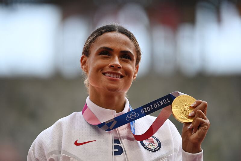 Gold medallist USA's Sydney Mclaughlin poses with her medal on the podium after the women's 400m hurdles event during the Tokyo 2020 Olympic Games.