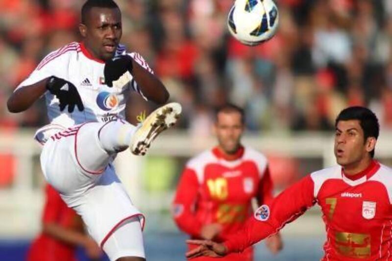 Al Jazira's midfielder Ibrahim Diaky, left, vies for the ball against Tractorsazi midfielder Mehdi Karimian. AFP