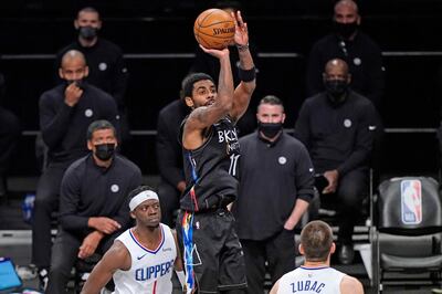 Brooklyn Nets guard Kyrie Irving (11) shoots as Los Angeles Clippers guard Reggie Jackson (1) and center Ivica Zubac (40) watch during the second half of an NBA basketball game, Tuesday, Feb. 2, 2021, in New York. (AP Photo/Kathy Willens)