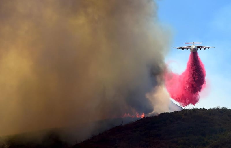 A helicopter drops fire retardant in the mountains off Placerita Canyon Road in Santa Clarita, California.  Frdederic J Brown / AFP Photo