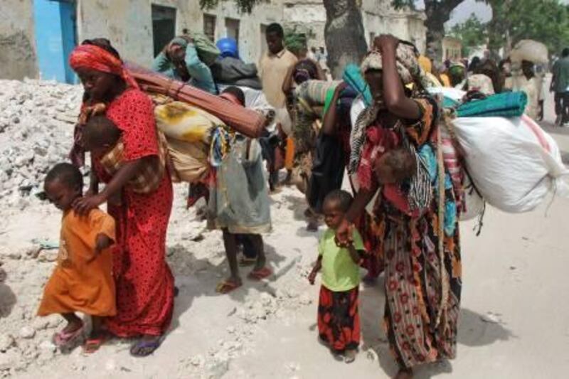 Somalis from southern Somalia carrying their belongings make their way to a new camp for internally displaced people in Mogadishu Tuesday, July 26, 2011. The U.N. will airlift emergency rations this week to parts of drought-ravaged Somalia that militants banned it from more than two years ago _ a crisis intervention to keep hungry refugees from dying along what an official calls the "roads of death." The foray into the famine zone is a desperate attempt to reach at least 175,000 of the 2.2 million Somalis whom aid workers have not yet been able to help. Tens of thousands already have trekked to neighboring Kenya and Ethiopia, hoping to get aid in refugee camps. (AP Photo/Farah Abdi Warsameh) *** Local Caption ***  East Africa Famine.JPEG-0ce7b.jpg