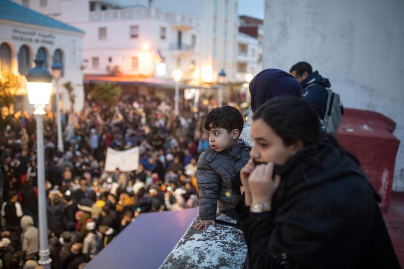 Families watch from a balcony as demonstrators in Fnideq, northern Morocco, protest against economic conditions and the closure of the border with the Spanish enclave of Ceuta. AP Photo