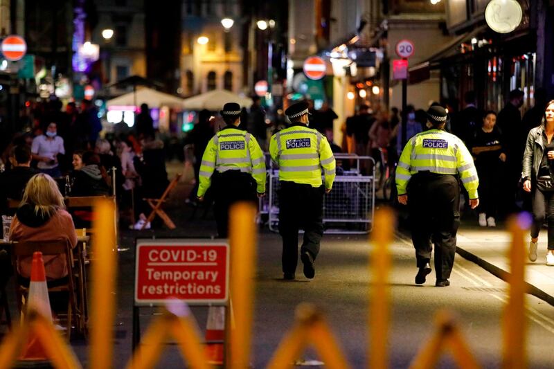 Police patrol in Soho, in central London on September 24, 2020, on the first day of the new earlier closing times for pubs and bars in England and Wales, introduced to combat the spread of the coronavirus. Britain has tightened restrictions to stem a surge of coronavirus cases, ordering pubs to close early and advising people to go back to working from home to prevent a second national lockdown. / AFP / Tolga AKMEN
