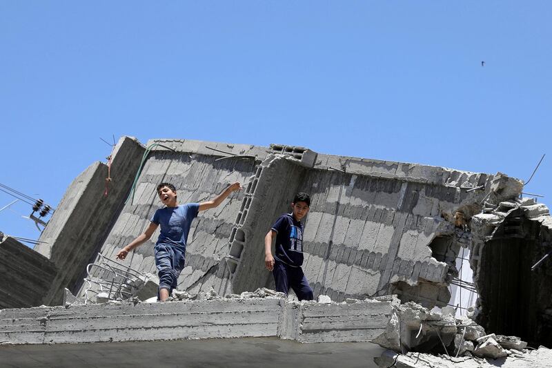 A Palestinian boy dances on the rubble of a building. Reuters