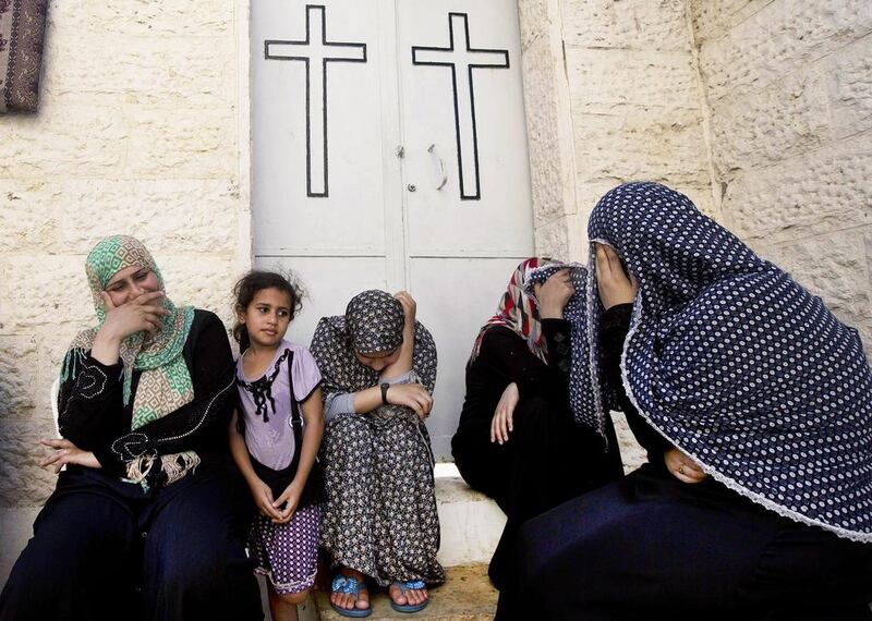 Displaced Palestinian women sit in a Greek Orthodox church where many Palestinians are taking shelter in Gaza City on July 23, 2014. AFP Photo

