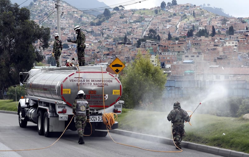Colombian soldiers disinfect a zone at neighborhood next to a military base as part of the campaign against the spread of coronavirus in Bogota, Colombia.  EPA
