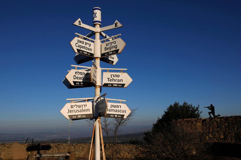 A metal cutout of an Israeli soldier stands behind signs pointing out distances to different cities at an army post on Mount Bentalin in the Israeli-annexed Golan Heights. AFP