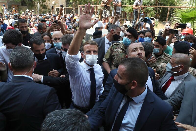 French President Emmanuel Macron, center, gestures as he visits the Gemayzeh neighborhood, which suffered extensive damage from an explosion on Tuesday that hit the seaport of Beirut, Lebanon, Thursday, Aug. 6, 2020. (AP Photo/Bilal Hussein)