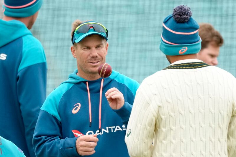 Australia's David Warner chats to teammates during training. AP