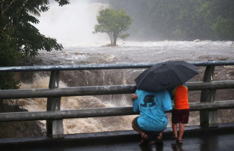 People gather on a bridge to watch the Wailuku River flood waters on the Big Island, in Hilo, Hawaii. Hurricane Lane has brought more than a foot of rain to some parts of the Big Island which is under a flash flood warning. Mario Tama / AFP