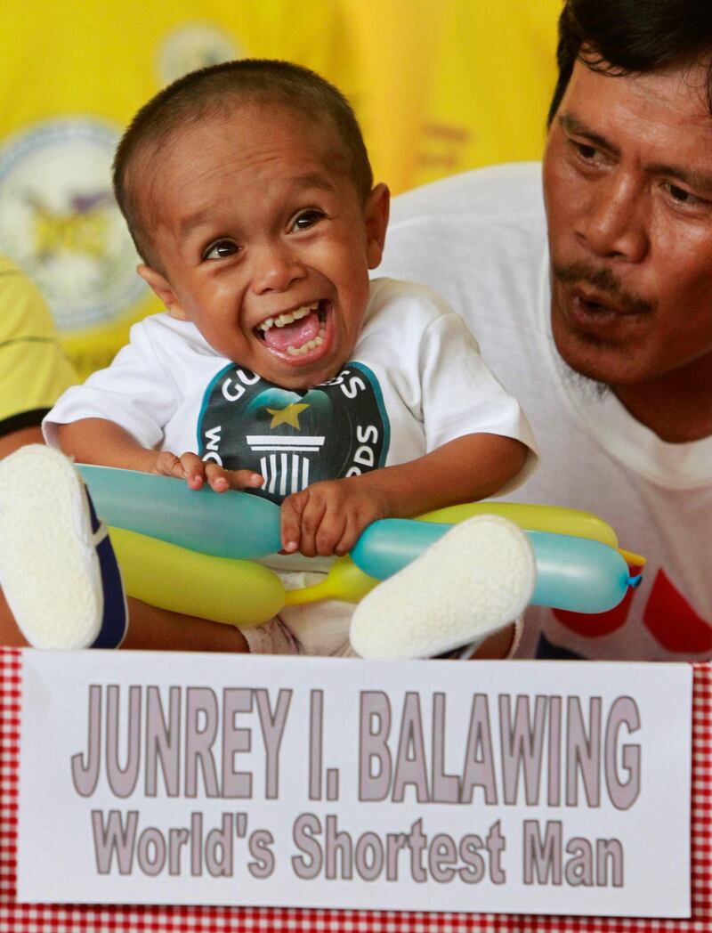 Reynaldo Balawing talks to his son Junrey, the "World's Shortest Living Man" declared by the Guinness World Records, in Sindangan, Zamboanga del Norte in southern Philippines June 12, 2011. Junrey Balawing was certified by the Guinness World Record as the shortest man in the world with standing and lying down average measurement of 23.5 inches (59.93 cm) on his 18th birthday on Sunday. The previous title holder is Khagendra Thapa Magar from Nepal who measures 26.4 inches (67.06 cm), and 2.9 inches (7.36 cm) taller.    REUTERS/Erik de Castro (PHILIPPINES - Tags: SOCIETY PROFILE) *** Local Caption ***  EDC514_PHILIPPINES-_0612_11.JPG