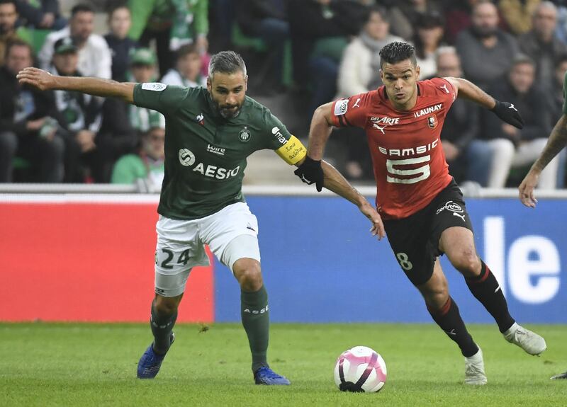 Rennes' French midfielder Hatem Ben Arfa (C) fights for the ball with Saint-Etienne's French defender Loic Perrin (L) during the French L1 football match between AS Saint-Etienne and Stade Rennais FC  at the Geoffroy Guichard stadium in Saint-Etienne, central France on October 21, 2018. / AFP / PHILIPPE DESMAZES
