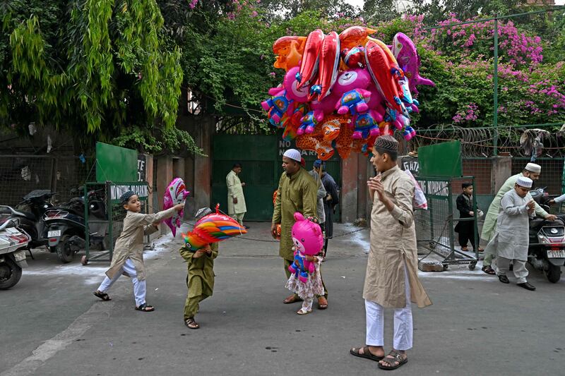 Children play with balloons after Eid Al Fitr prayers outside the Jama Masjid mosque, New Delhi, India. AFP