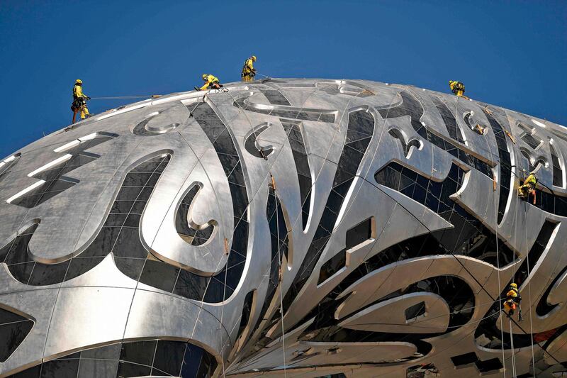 Workers clean the exterior of the Museum of the Future in Dubai's financial district.   AFP