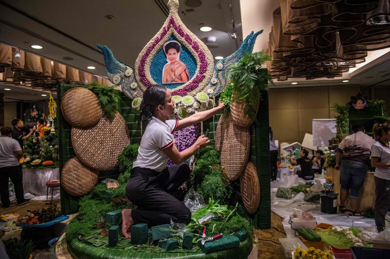 A Thai woman puts together the background to a decoration that will include different vegetable and fruit decorations during a fruit and vegetable carving competition in Bangkok. Robert Schmidt / AFP