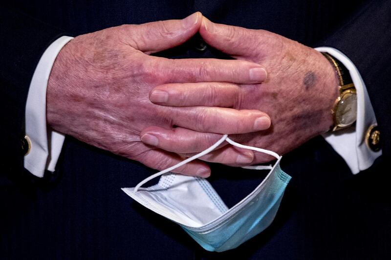 FILE - In this June 16, 2020, file photo Senate Majority Leader Mitch McConnell, R-Ky., holds a face mask in his hands during a news conference following a Senate policy luncheon on Capitol Hill in Washington. On Friday, June 26, Vice President Mike Pence said Americans should look to their state and local leadership for modeling their behavior during the coronavirus pandemic. The comments only days after President Donald Trump held two campaign events that drew hundreds of participants but few wearing masks. (AP Photo/Andrew Harnik, File)