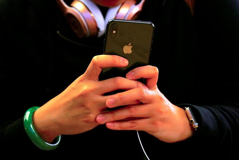 FILE PHOTO: A customer holds the iPhone X during the global launch of the new Apple product in central Sydney, Australia, November 3, 2017.     REUTERS/David Gray/File Photo