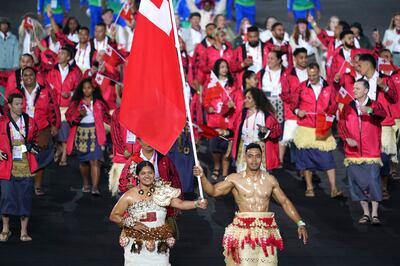 Team Tonga let by rugby captain Sione Tupou and weightlifter Kuinini Manumua. AP