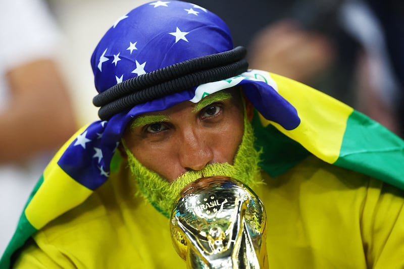 A Brazil fan with a replica of the World Cup trophy. Reuters