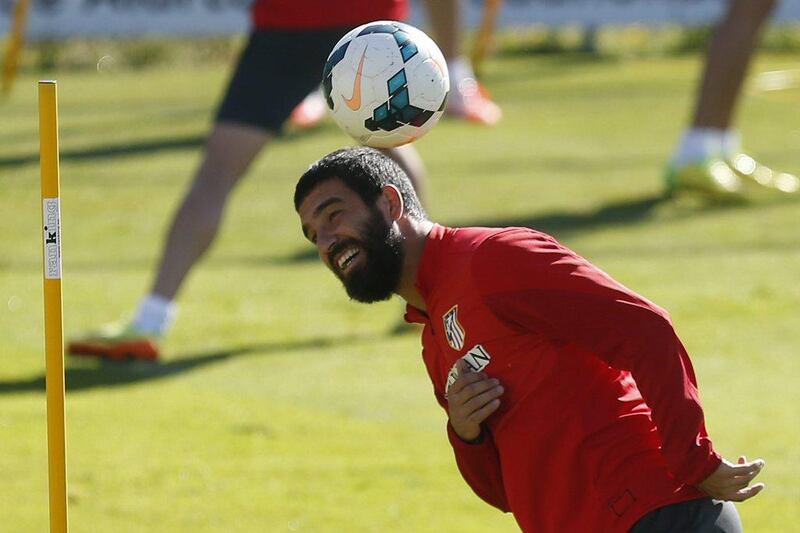 Atletico Madrid's Arda Turan balances the ball on his head during an Atletico training session on Friday before they face off with Barcelona on Saturday. Javier Lizon / EPA / May 16, 2014