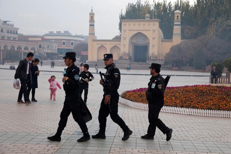 In this Nov. 4, 2017 photo, Uighur security personnel patrol near the Id Kah Mosque in Kashgar in western China's Xinjiang region. Authorities are using detentions in political indoctrination centers and data-driven surveillance to impose a digital police state in the region of Xinjiang and its Uighurs, a 10-million strong, Turkic-speaking Muslim minority Beijing fears could be influenced by extremism. (AP Photo/Ng Han Guan)