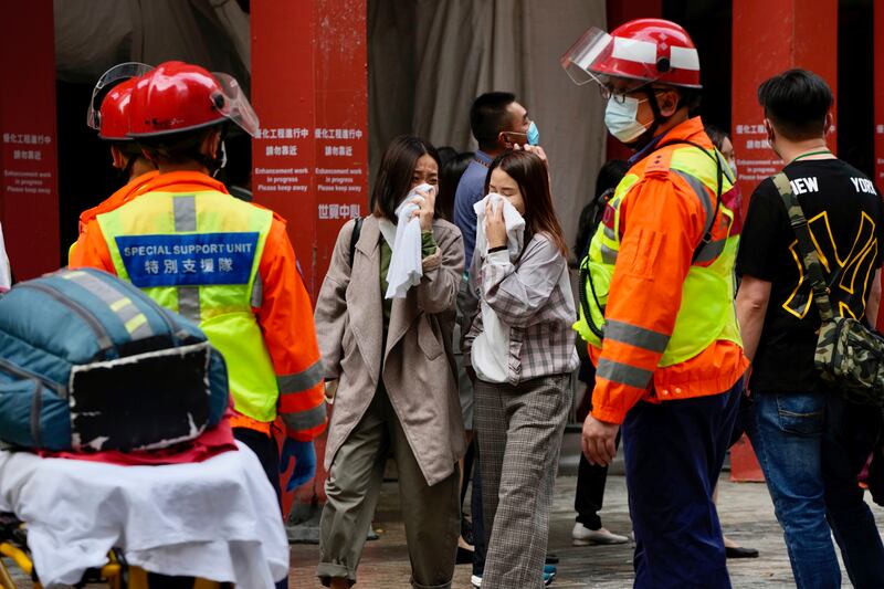 People walk out from the Hong Kong World Trade Centre after a major fire broke out on Wednesday. AP