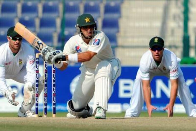 Pakistani captain Misbah-ul-Haq (C) plays a shot as South African wicketkeeper Mark Boucher (L) and teammate AB de Villiers look on during the fifth and last day of the second Test match between South Africa and Pakistan at the Abu Dhabi cricket stadium on November 24, 2010. South Africa set Pakistan a target of 354 to win the second Test after declaring their second innings at 203-5 on the fifth and final day. AFP PHOTO/ AAMIR QURESHI
 *** Local Caption ***  731924-01-08.jpg