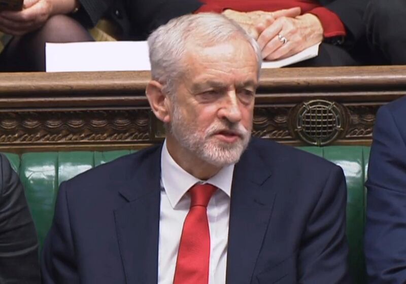 Labour leader Jeremy Corbyn says something under his breath after the British Prime Minister Theresa May likened Labour's attempt to table a no confidence motion in her to a pantomime, during the weekly Prime Minister's Questions in the House of Commons, London, Wednesday Dec. 19, 2018.  With 100 days until Britain leaves the European Union, the government was publishing long-awaited plans Wednesday for a post-Brexit immigration system that will end free movement of EU citizens to the U.K. (House of Commons/PA via AP)