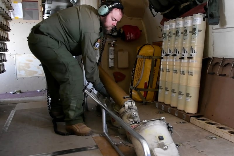 A Royal Canadian Air Force serviceman drops sonar buoys from a surveillance aircraft. Reuters