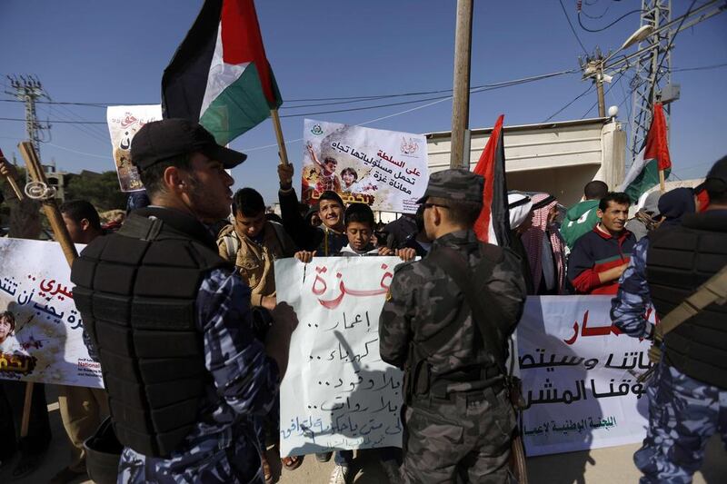 Palestinian protesters in Gaza hold up banners attacking the PA (AFP PHOTO / MOHAMMED ABED)

