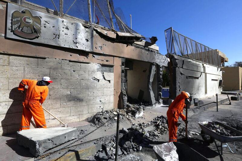 Workers clean up outside the UAE embassy in Tripoli after it was targeted by a car bomb on November 13. EPA