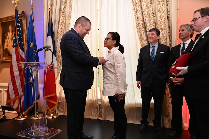 Guillaume Gomez, Special Representative of the President of France for Gastronomy, gives the insignia of Officier du Merite Agricole to Ms Comerford in 2022. AFP