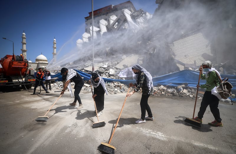 Palestinian volunteers and municipal workers clear the rubble of the Hanadi compound in Gaza City's Rimal district. AFP