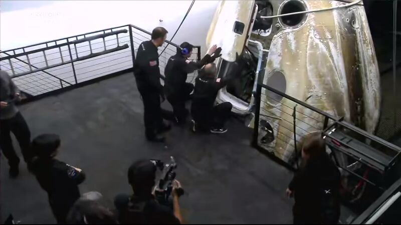 The capsule's hatch is opened for the first time after arrival
