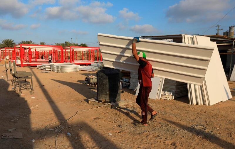 A labourer carries a panel at the construction site of a field hospital for Covid-19 patients in Deir Al Balah in the central Gaza Strip. AFP