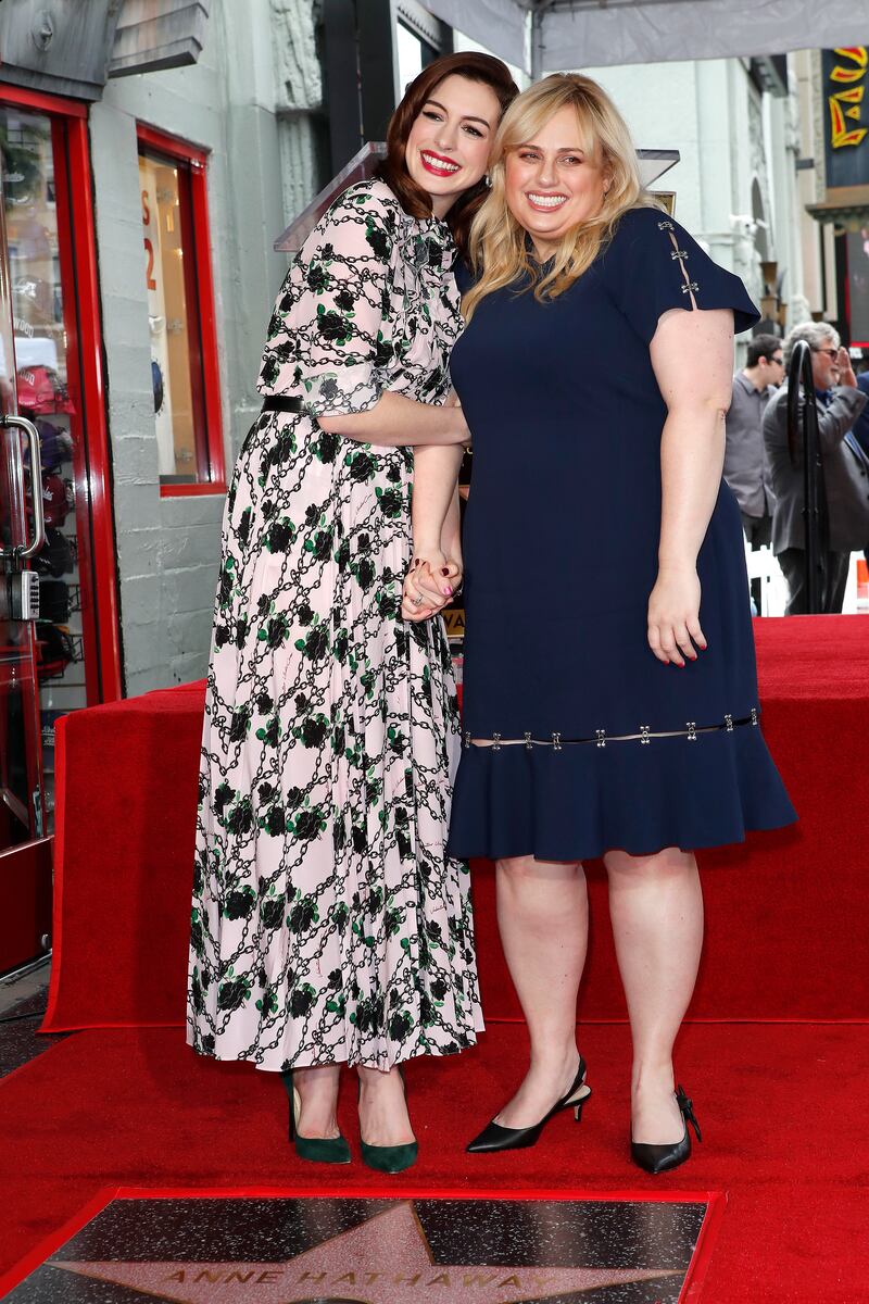 Anne Hathaway and Rebel Wilson, wearing a blue T-shirt dress, on the Hollywood Walk of Fame in California on May 9, 2019. EPA