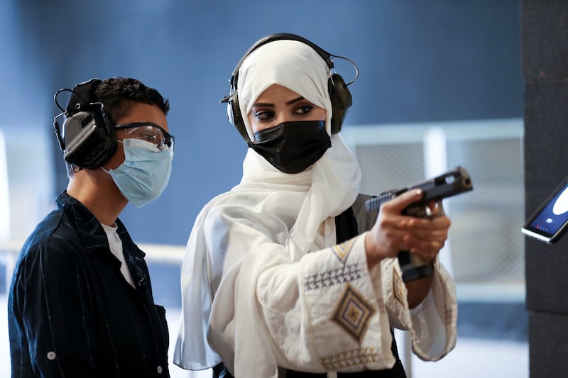 Mona Al Khurais teaches a Saudi Arabian boy how to use firearms.