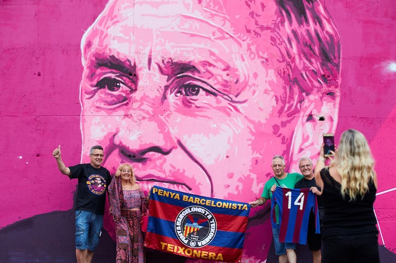 Barcelona's fans pose for a photo next to Johan Cruyff's graffiti during the opening of the new stadium in his name. EPA
