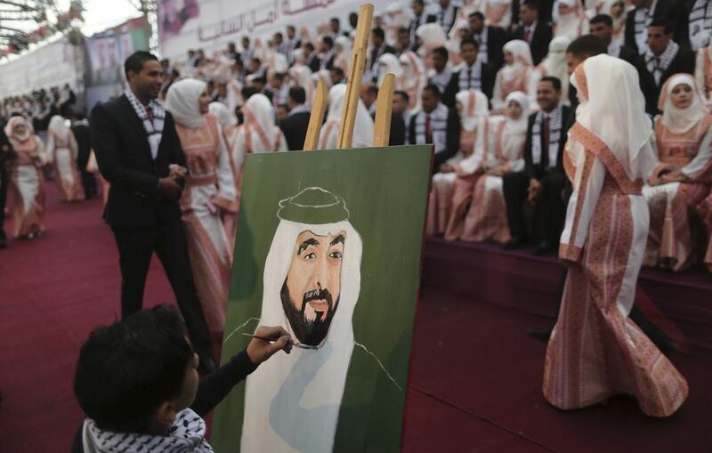 A Palestinian boy paints a picture of President Sheikh Khalifa during a mass wedding for 200 couples in Gaza City on April 11. The wedding was funded by the Khalifa bin Zayed Al Nahyan Foundation. Mohammed Salem / Reuters