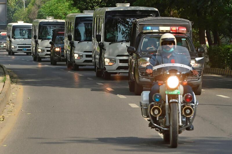Police vans escort vehicles carrying Pakistan's cricket team as they leave for the airport in Lahore on Sunday for the tour of England. AFP