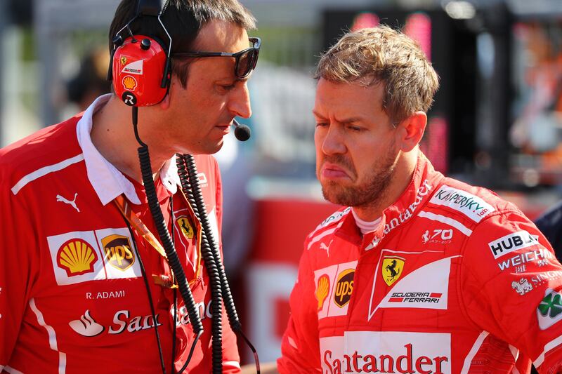 epa06252100 German Formula One driver Sebastian Vettel (R) of Scuderia Ferrari talks with a team member on the grid before the start of the Japanese Formula One Grand Prix at the Suzuka Circuit in Suzuka, central Japan, 08 October 2017.  EPA/DIEGO AZUBEL