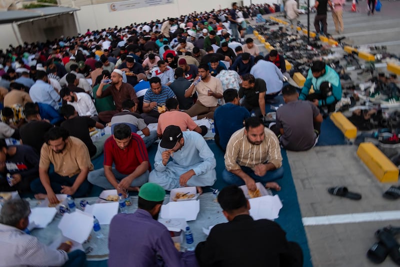 Men sit with iftar meals outside Al Farooq Omar bin Al Khattab Mosque to break the day's fasting. Antonie Robertson / The National