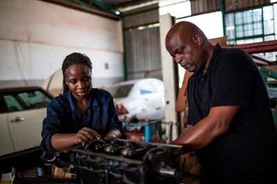 Aubrey Mulaudzi, 56, a diesel mechanic who had been banking with VBS Mutual Bank since 1989 assists Thabelo Nyelisani, 24, a trainee diesel mechanic doing her practicals in his workshop in Thohoyandou Limpopo, South Africa on December 12, 2018.  Fear spread through poor rural communities across South Africa in November when VBS, a regional bank that catered to poorer customers, collapsed. / AFP / GULSHAN KHAN
