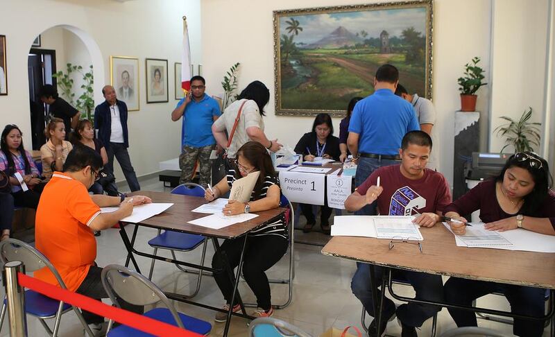 Filipinos learn about candidates before casting their vote on Monday at the Philippine embassy in Abu Dhabi. Ravindranath K / The National