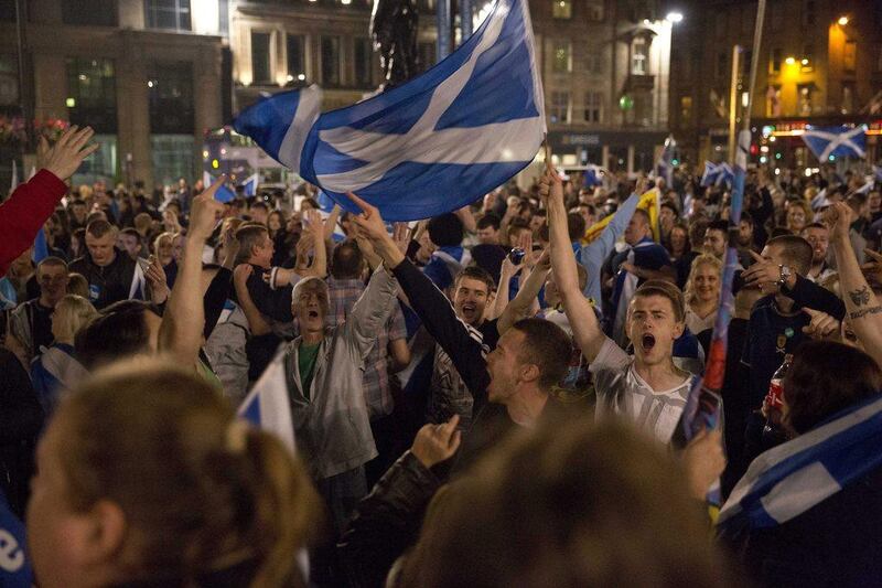 Supporters of the Yes campaign in the Scottish independence referendum cheer with Scottish Saltire flags as they await the result after the polls closed, in George Square, Glasgow, Scotland. Matt Dunham / AP Photo