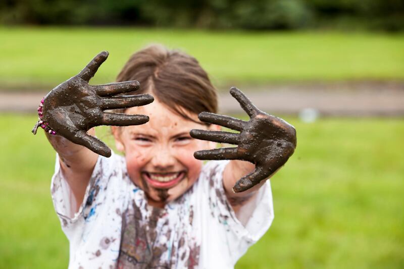 Close up of muddy hands on girl. Getty Images